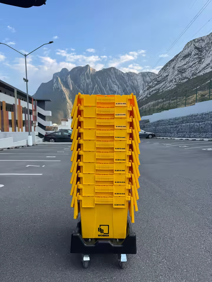 Cajas reutilizables amarillas de Mobber frente a las montañas de Monterrey