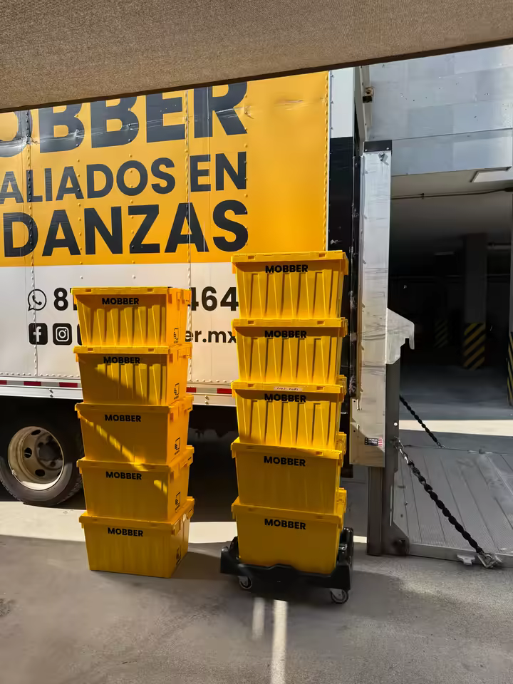 Cajas amarillas reutilizables Mobber junto a su camión de mudanzas